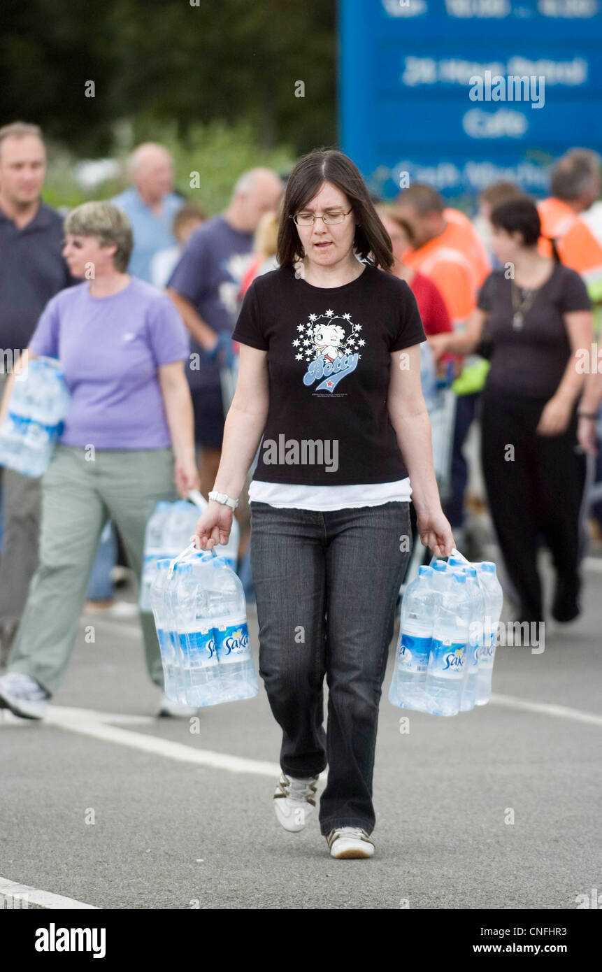 Flood victims - residents of Gloucester collect emergency supplies of bottled water from the carpark of the main Tesco. Stock Photo