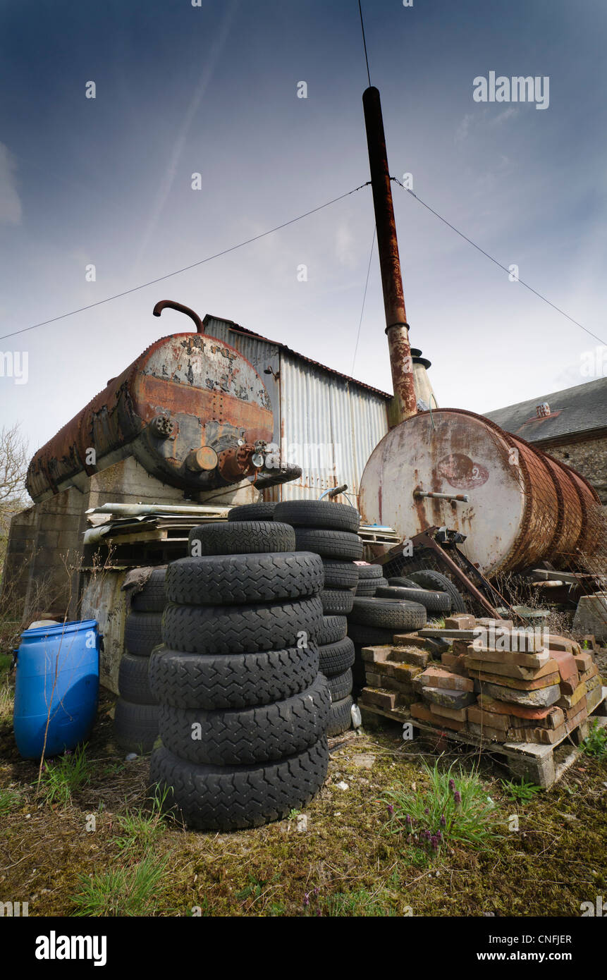 Pile of old disused tyres, rusty metal and old buildings Stock Photo