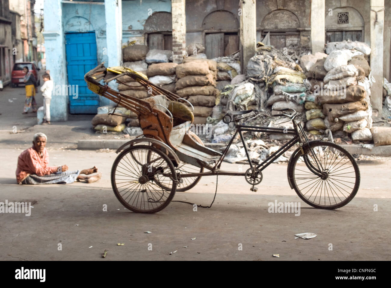 Kolkata man sitting next to his broken rickshaw Stock Photo