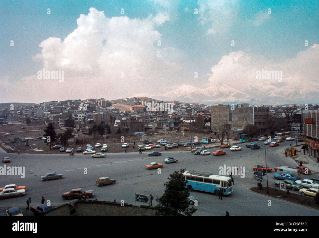 IRAN, TEHRAN: Busy intersection in Tehran, largest city and capital of Iran, with the Alborz Mountains. Archival photo, 1977 Stock Photo