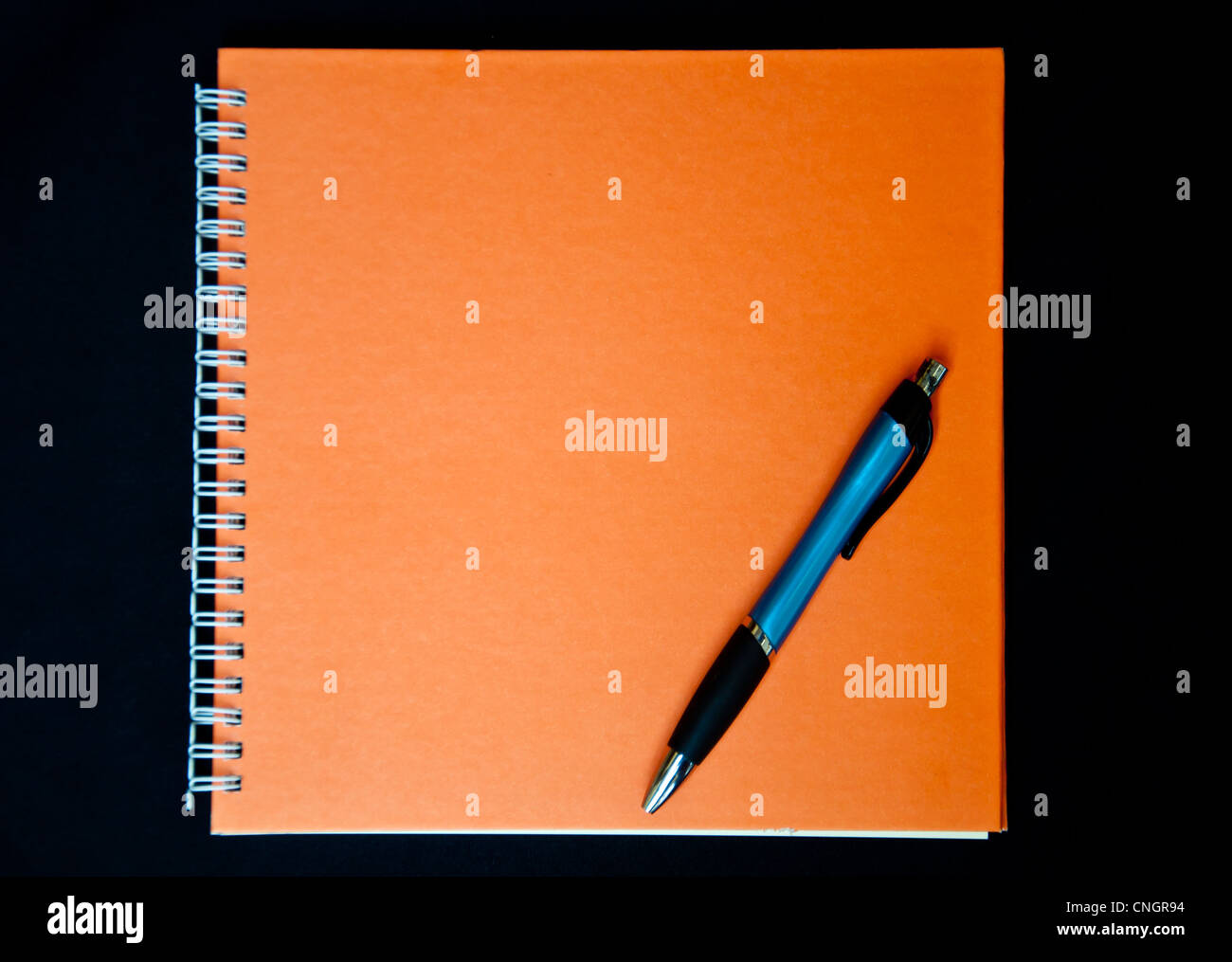 orange notebook and pen on black background Stock Photo Alamy