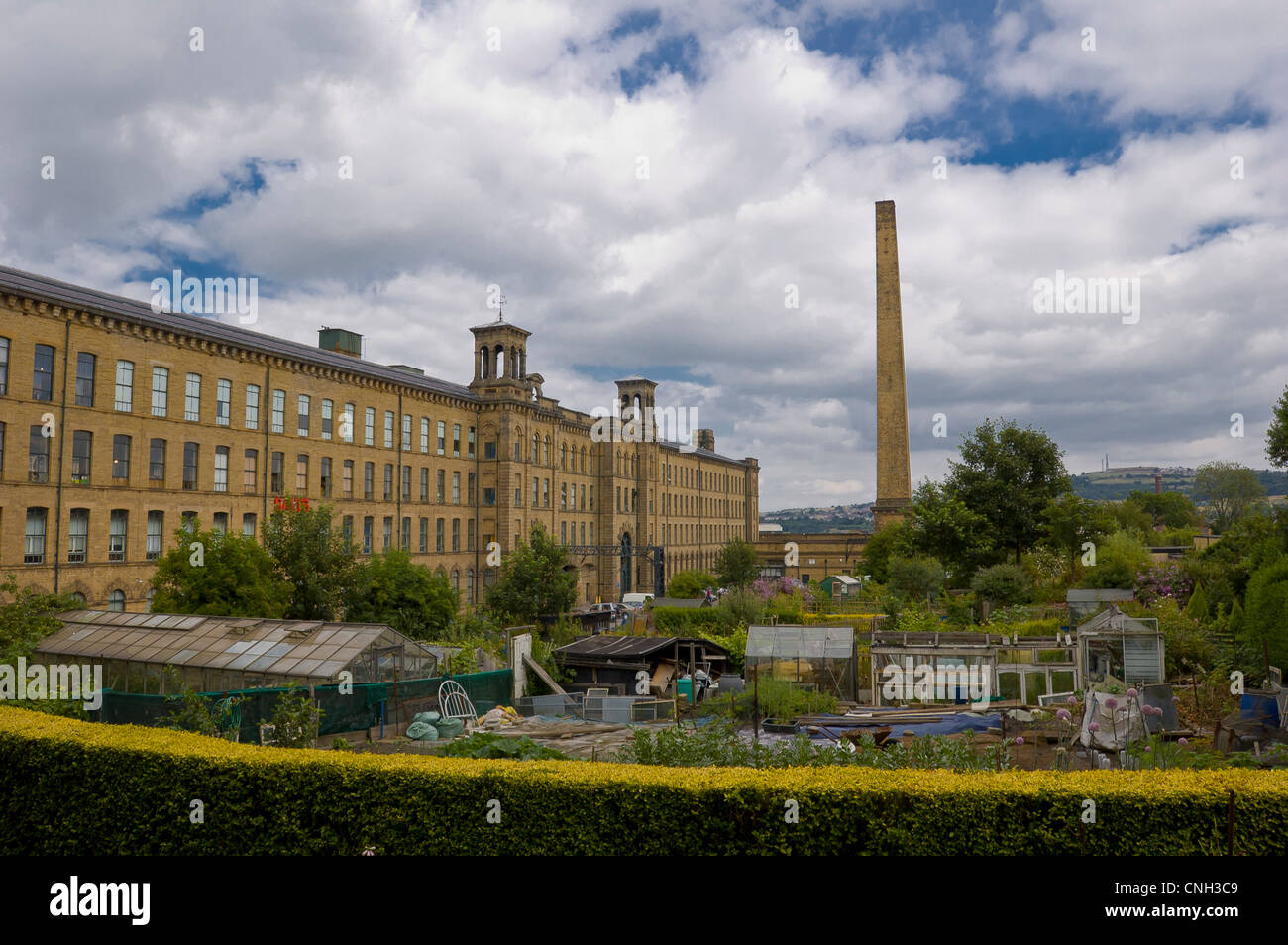 Allotments in the village of Saltaire in the city of leeds bradford in west yorkshire with the chimney stack and the mill Stock Photo