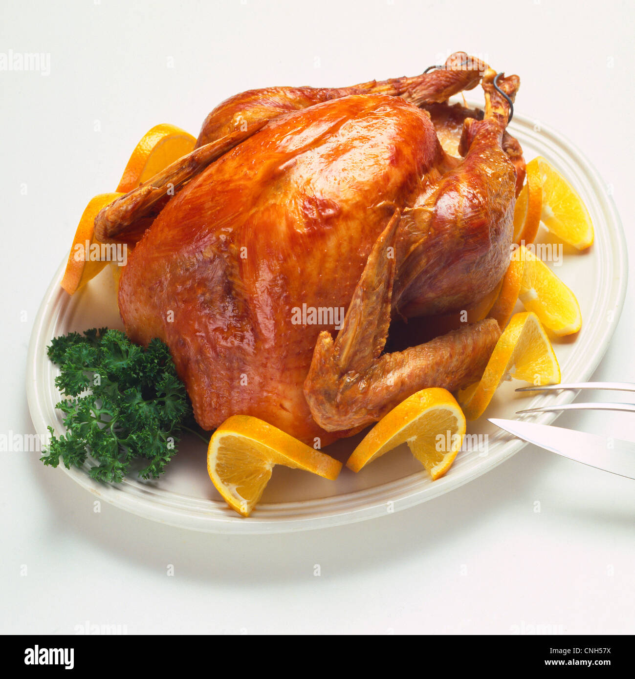 roast turkey garnished with orange slices and parsley on platter Stock Photo