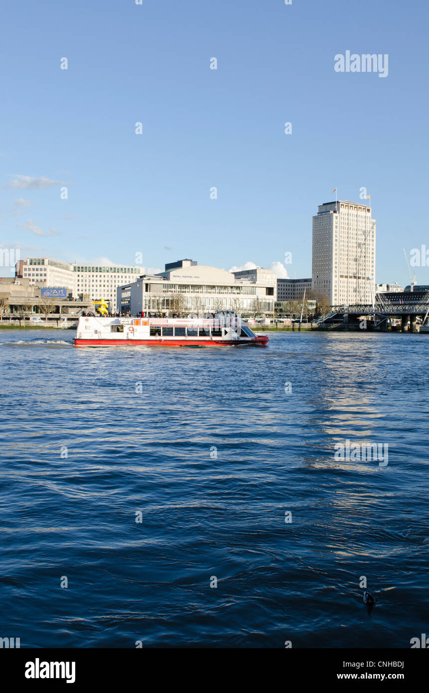 Citycruises boat on Thames with Royal Festival Hall and The Shell Centre behind. Stock Photo