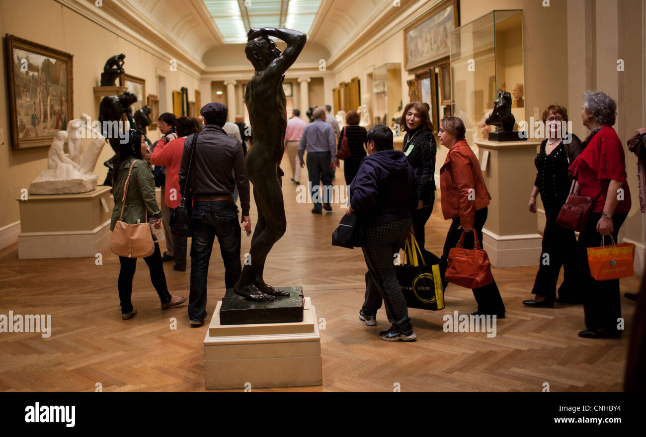 Visitors to the Metropolitan Museum of Art walk past bronze statues in