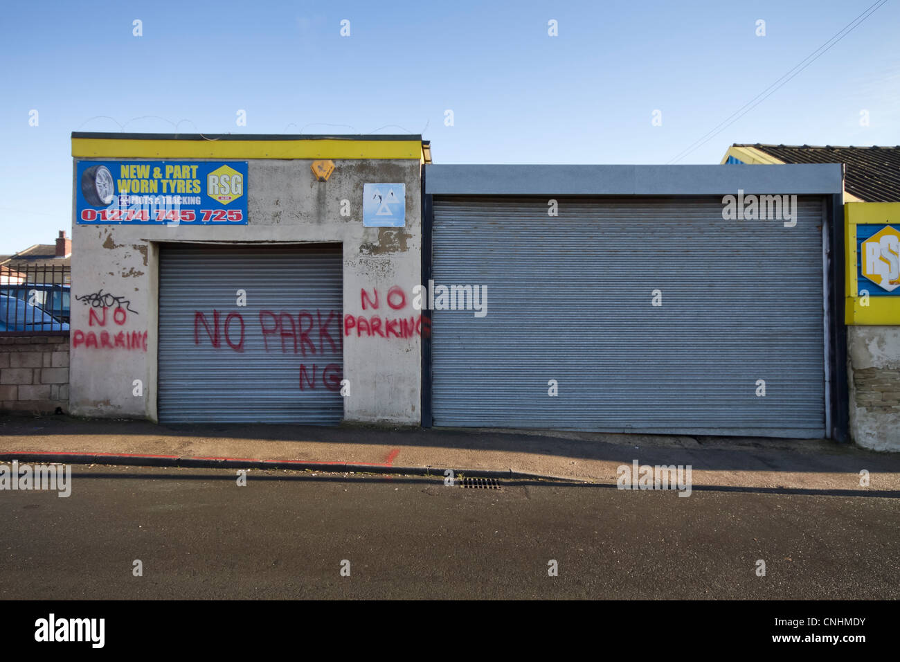 A no parking sign badly spray painted on a garage. Leeds Road, Bradford