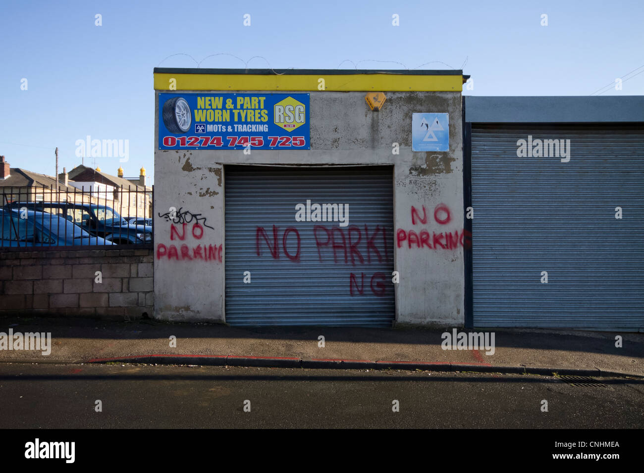 A no parking sign badly spray painted on a garage. Leeds Road, Bradford