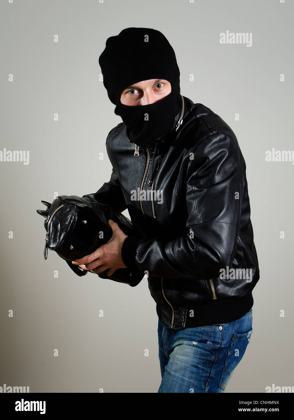 Portrait of male burglar with a handbag. Stock Photo