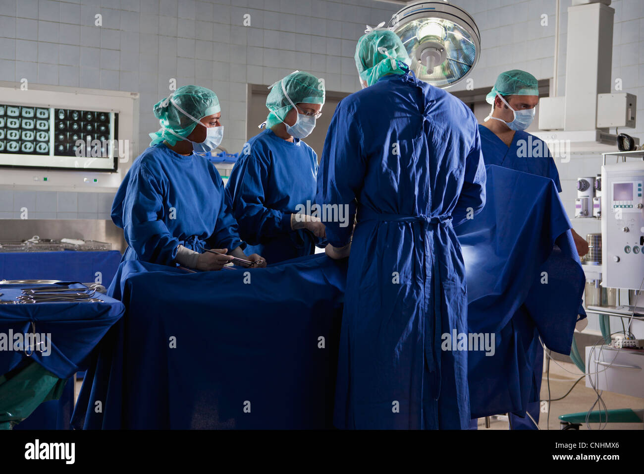 A surgery team operating on a patient in an operating room Stock Photo