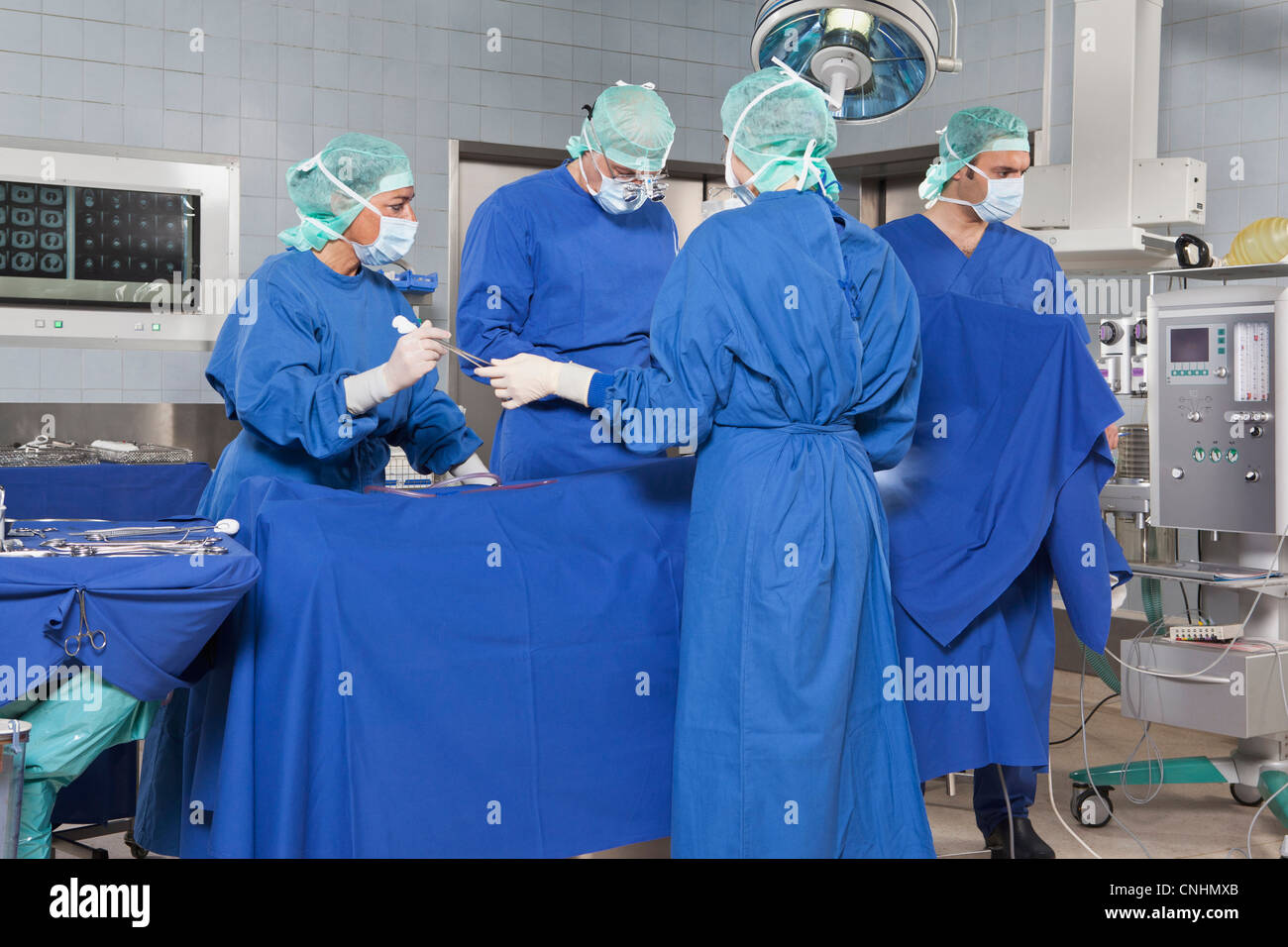 A surgery team operating on a patient in an operating room Stock Photo