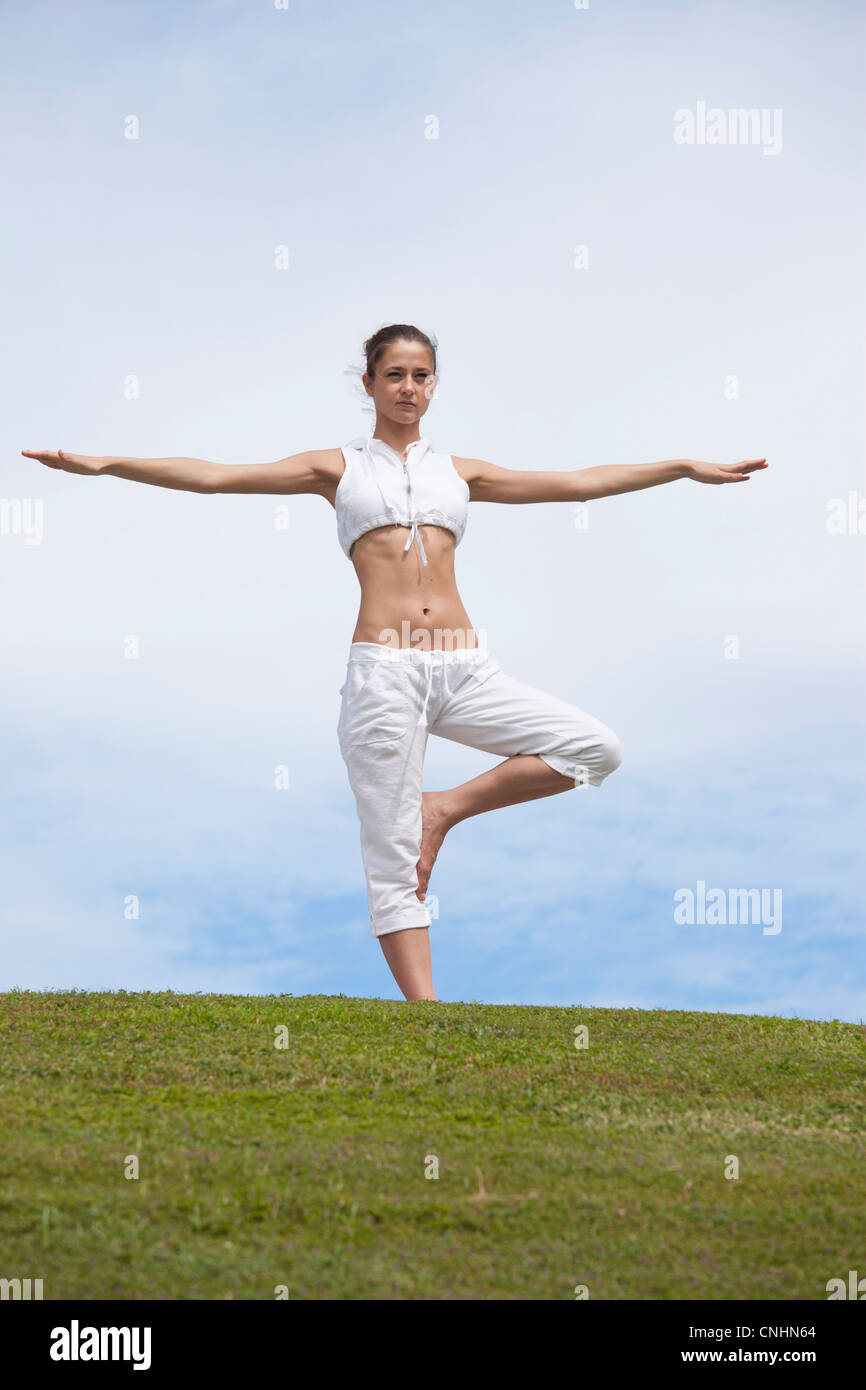Girl does yoga pose on hillside Stock Photo Alamy