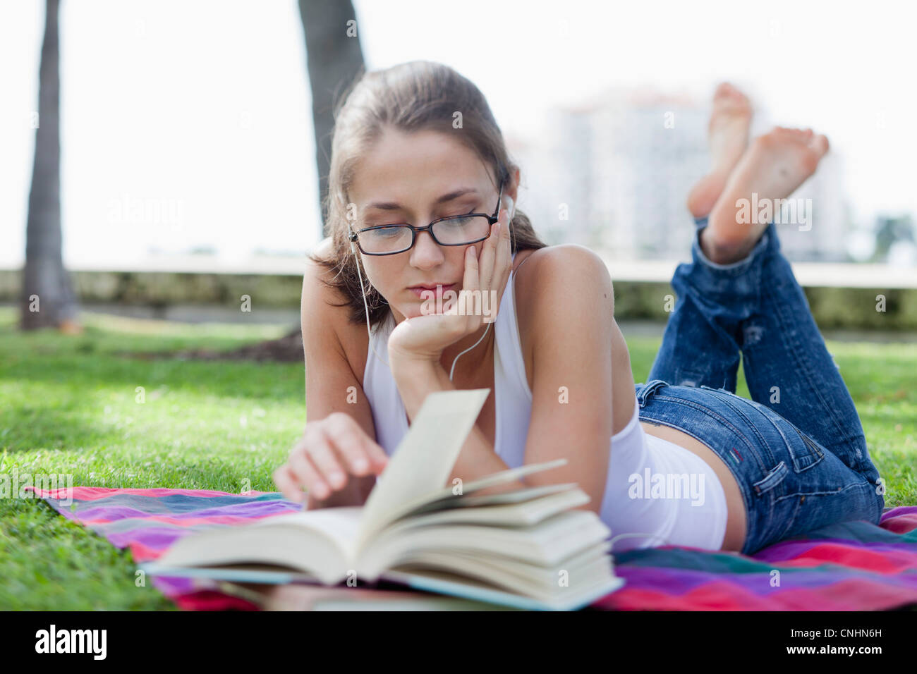 Girl lying down reading in park Stock Photo - Alamy