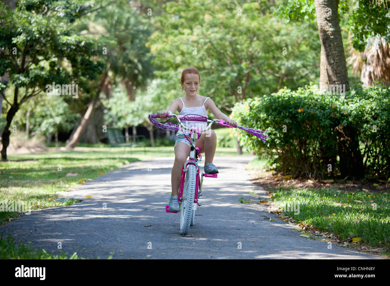 Girl riding bike through park Stock Photo - Alamy