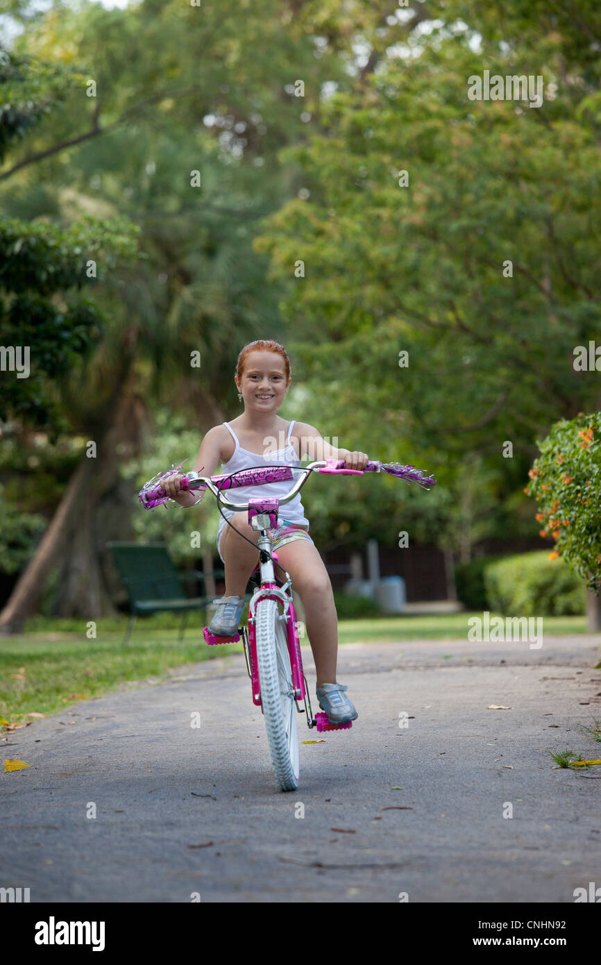 Girl riding bike through park Stock Photo - Alamy