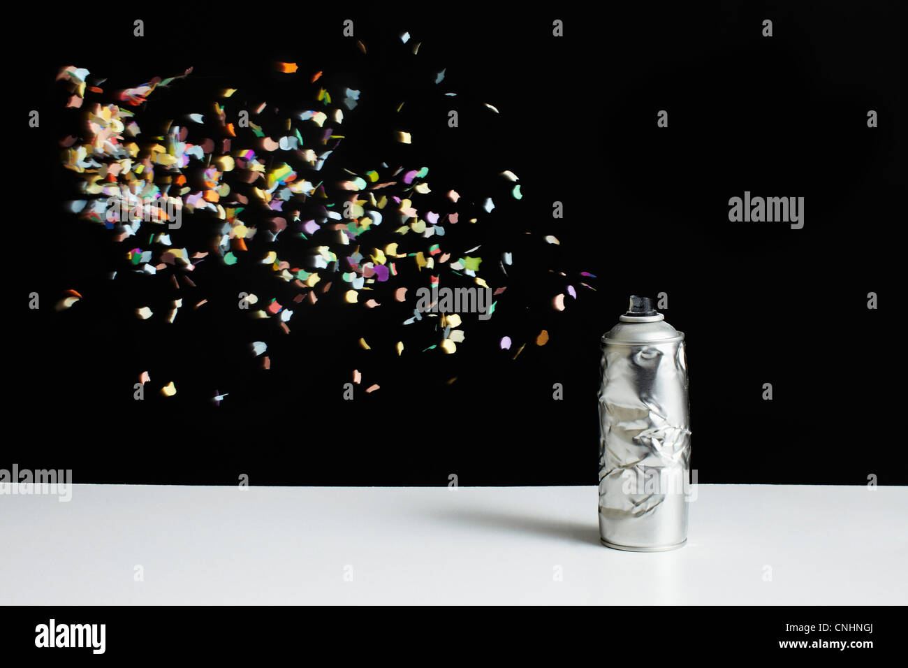 Floating confetti and a damaged spray paint can Stock Photo