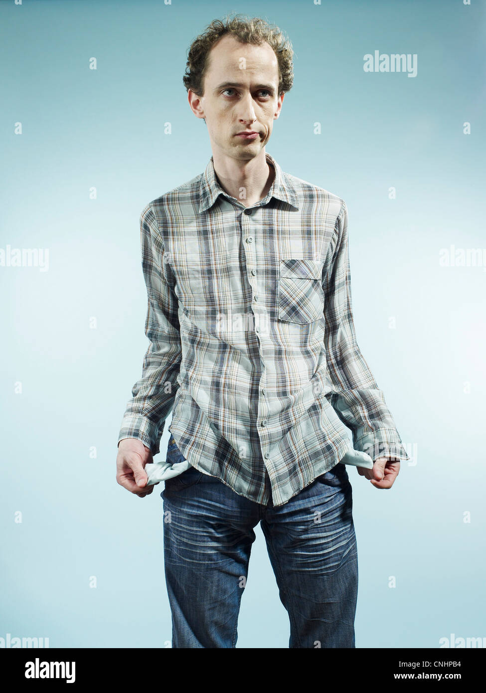 A man turns his pockets inside out to symbolize having no money Stock Photo
