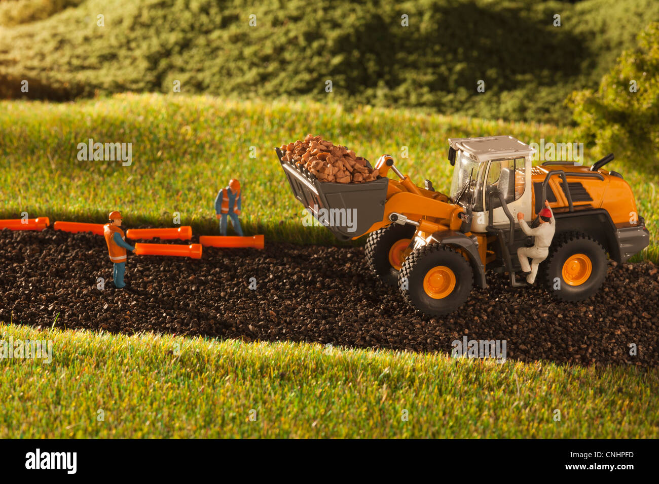 A diorama of miniature construction workers and a bulldozer Stock Photo