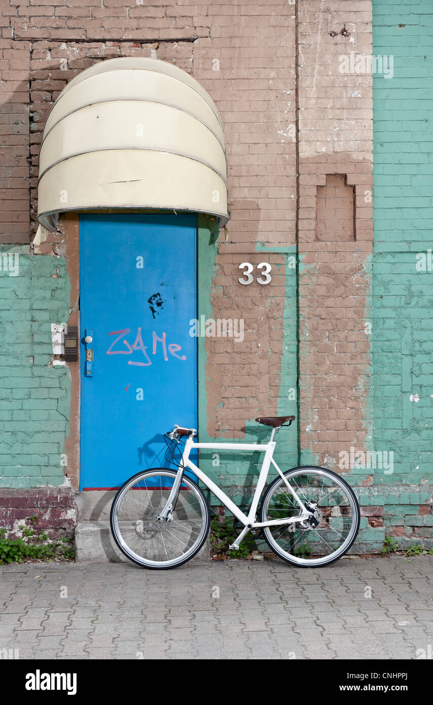 A bicycle in front of a rundown building Stock Photo