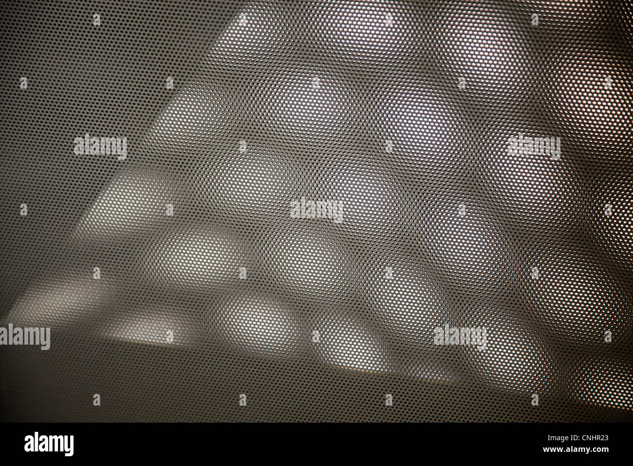 Shadows of hexagons on mesh screen Stock Photo