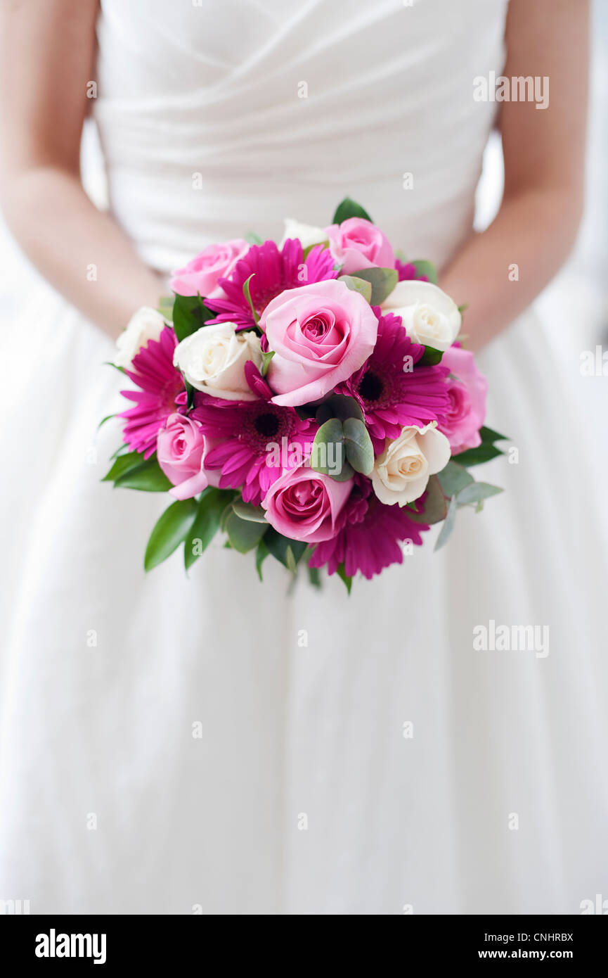cropped picture of bride holding wedding flowers bouquet at waist Stock Photo