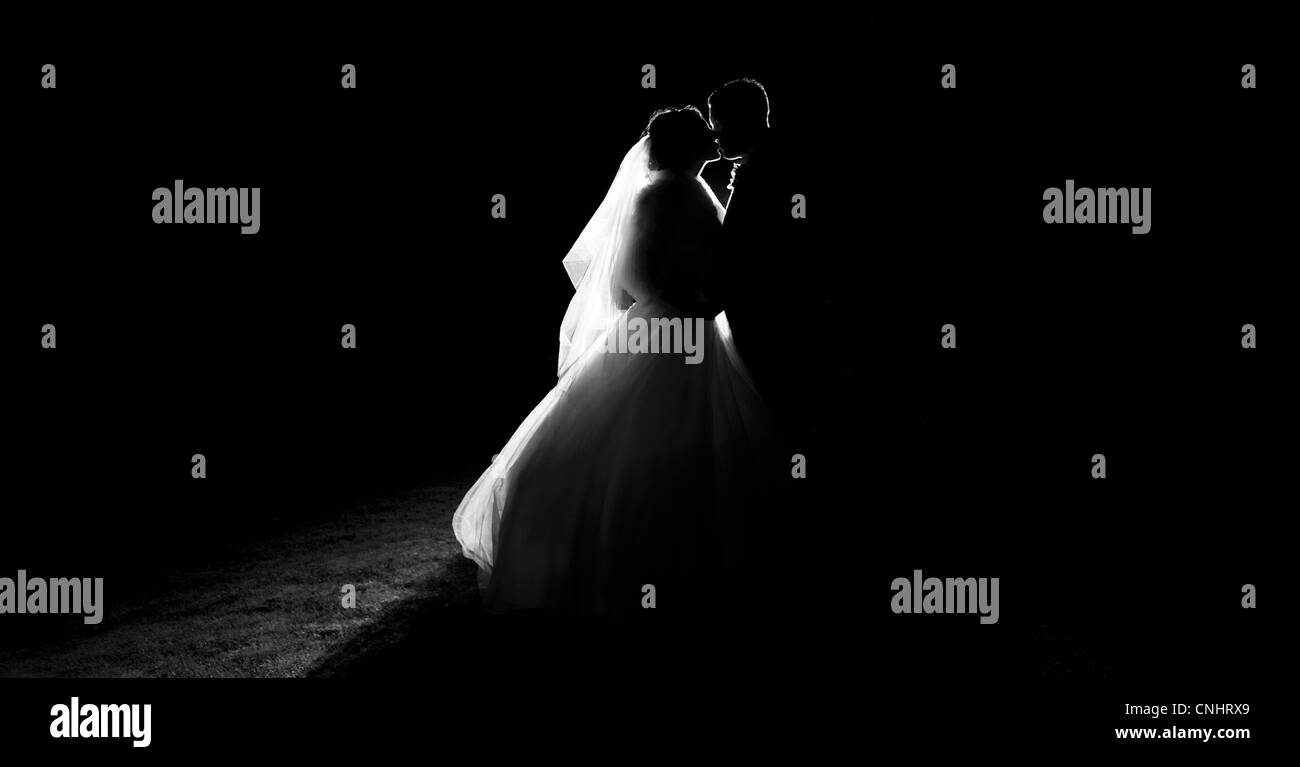 silhouette of bride and groom kissing on wedding day Stock Photo
