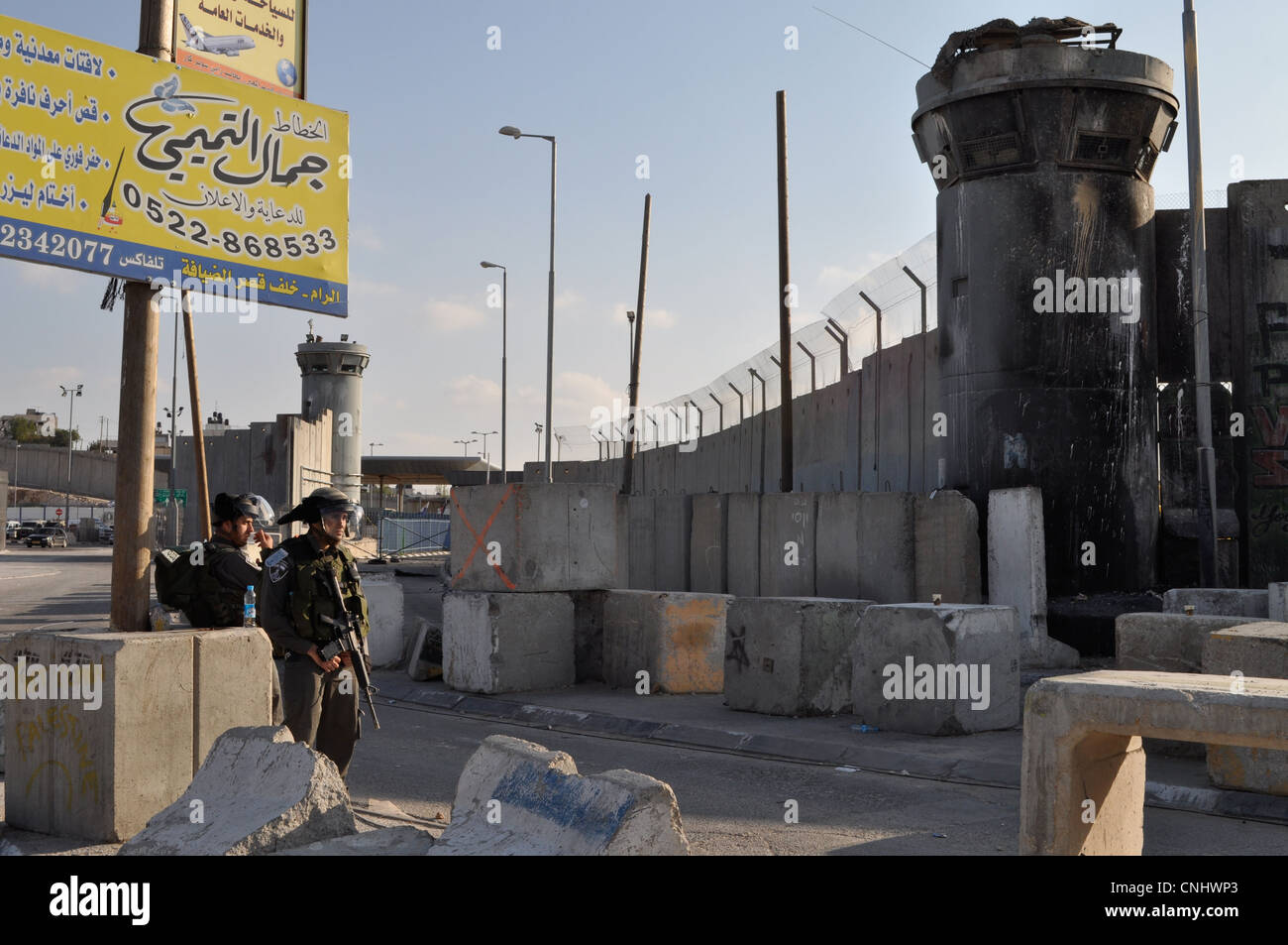 Israeli soldiers at the Qalandiya checkpoint during Land Day protests, March 30 2012 shelter by the apartheid wall or barrier Stock Photo