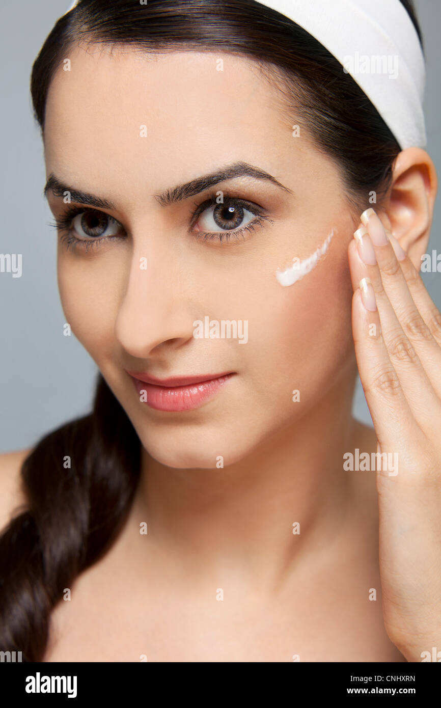 Beautiful woman with cream on her face Stock Photo