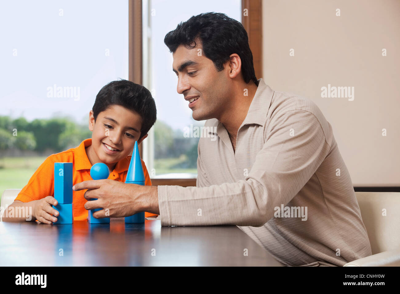 Father and son playing with building blocks Stock Photo