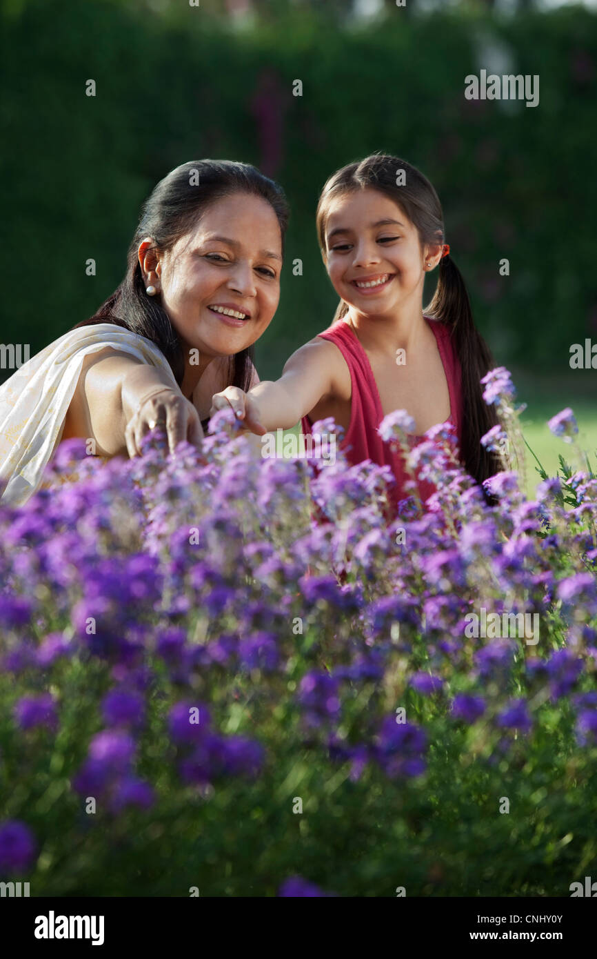 Girl and her grandmother looking at flowers Stock Photo