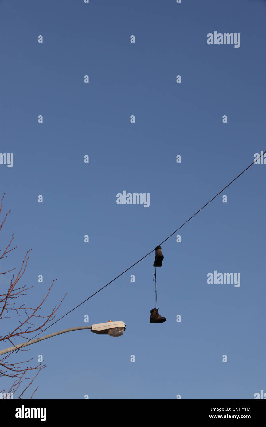 Shoefiti, trainers thrown high over wires, in Williamsburg, Brooklyn, NYC, USA Stock Photo