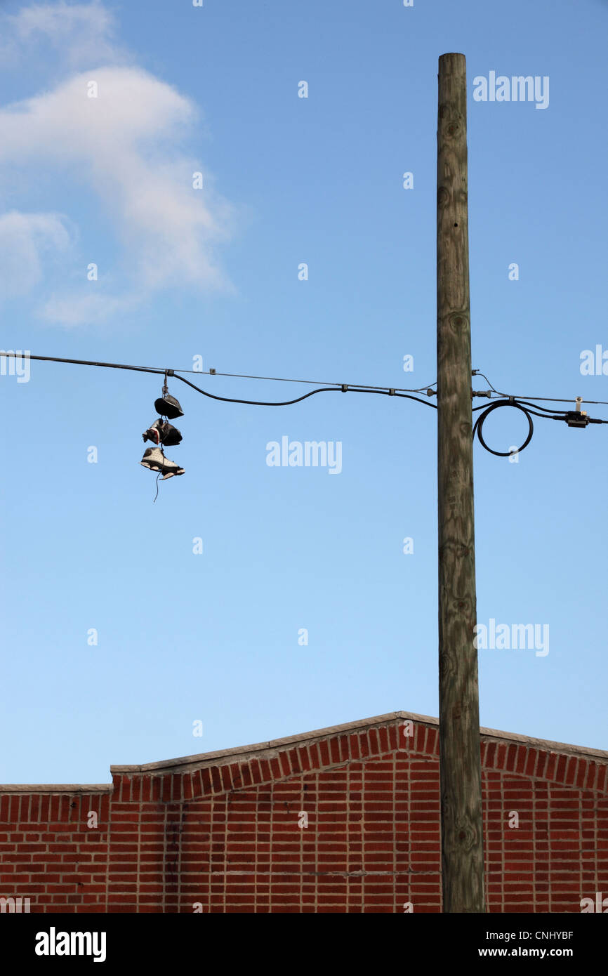 Shoefiti, trainers thrown high over wires, in Williamsburg, Brooklyn, NYC, USA Stock Photo