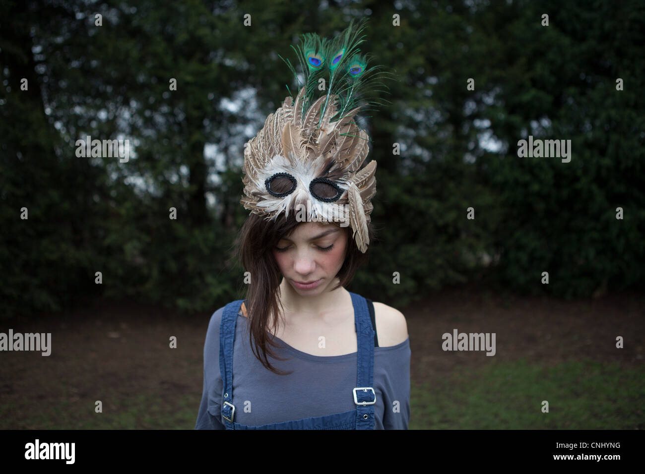 Young woman with feathered mask on her head Stock Photo
