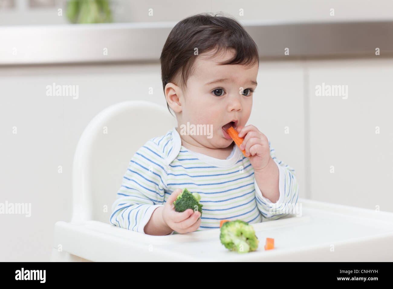 Baby boy eating healthy vegetables Stock Photo