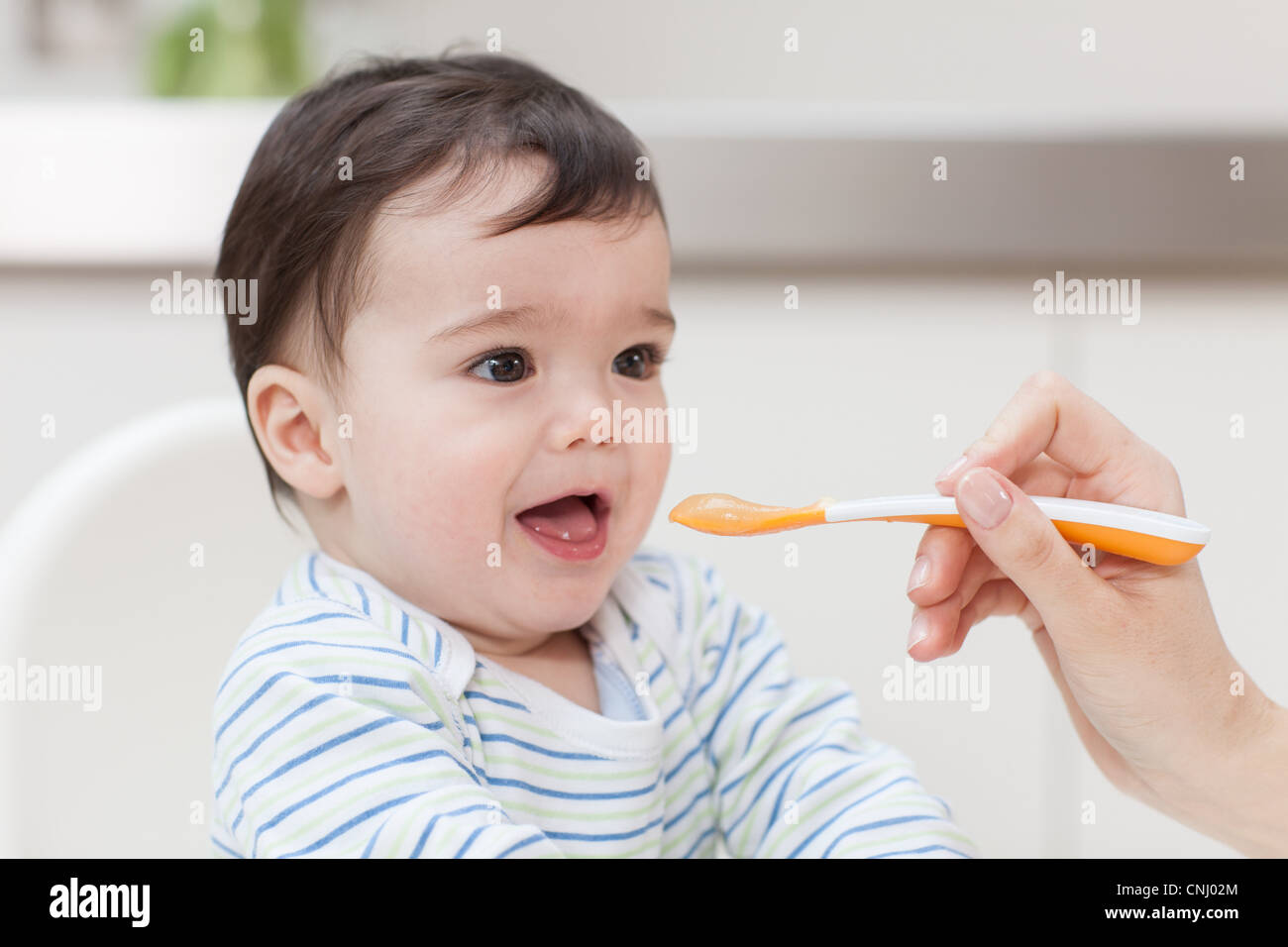 Baby boy being fed Stock Photo