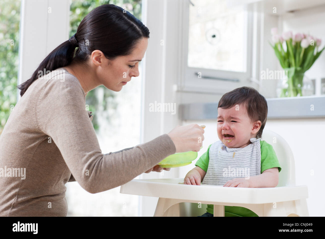Mother feeding crying baby son Stock Photo Alamy