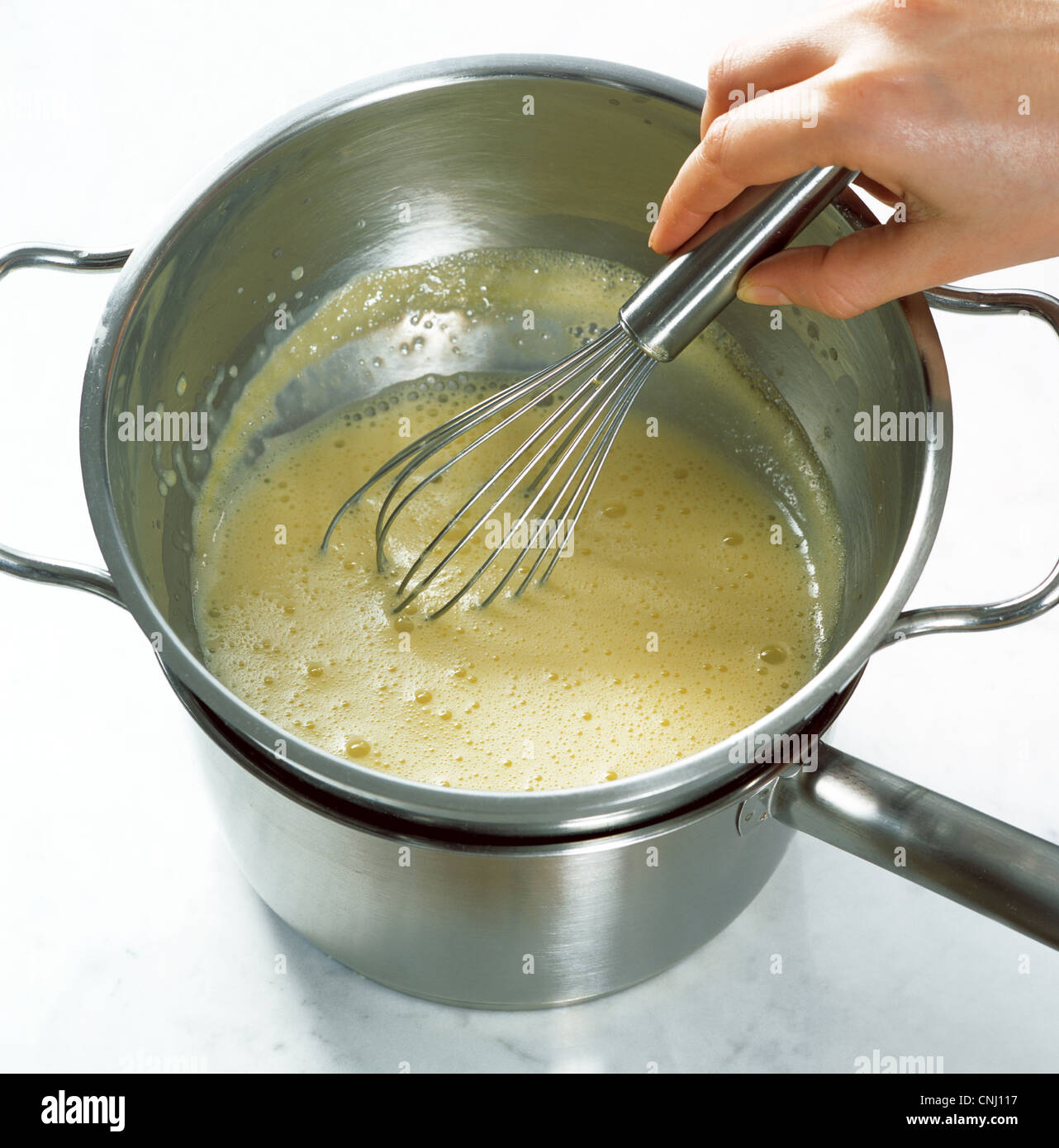 Stirring wine sauce in the double boiler Stock Photo