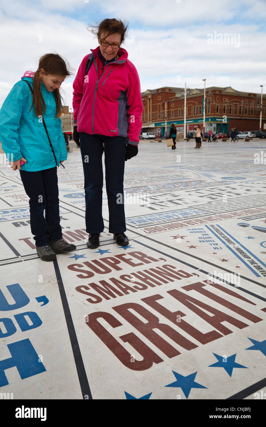 Mother and daughter on Blackpool Promenade looking at the Comedy Carpet, Lancashire, England Stock Photo