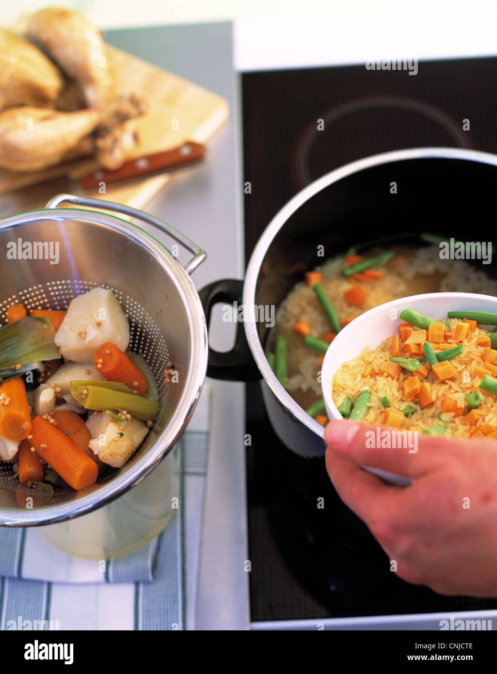 Adding vegetables and rice to the broth Stock Photo Alamy