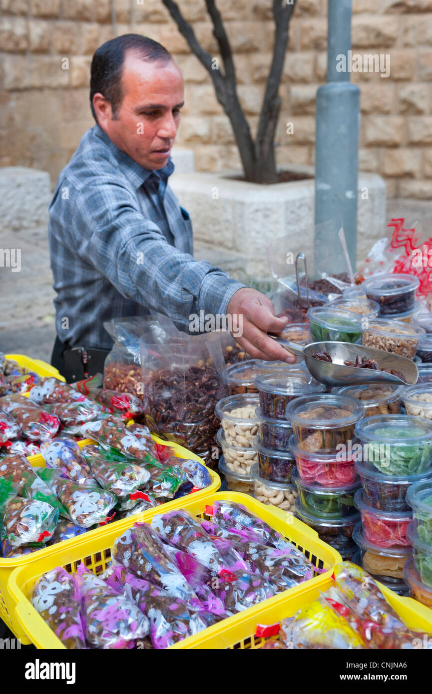 Middle Eastern Israel Jerusalem - man selling nuts and candy from a cart in the old city Stock Photo