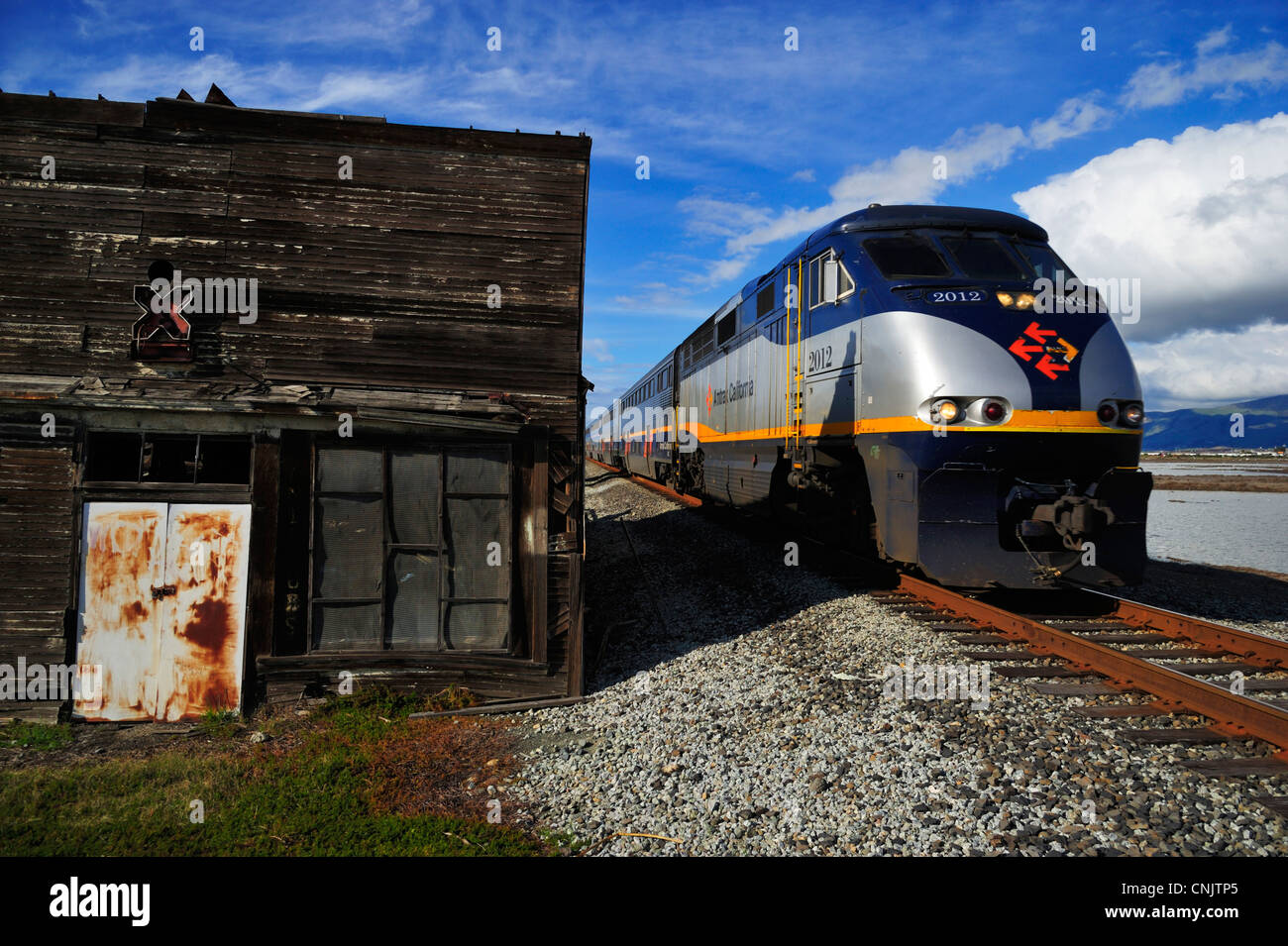 Amtrak train passing through the town of Alviso, San Jose CA Stock Photo