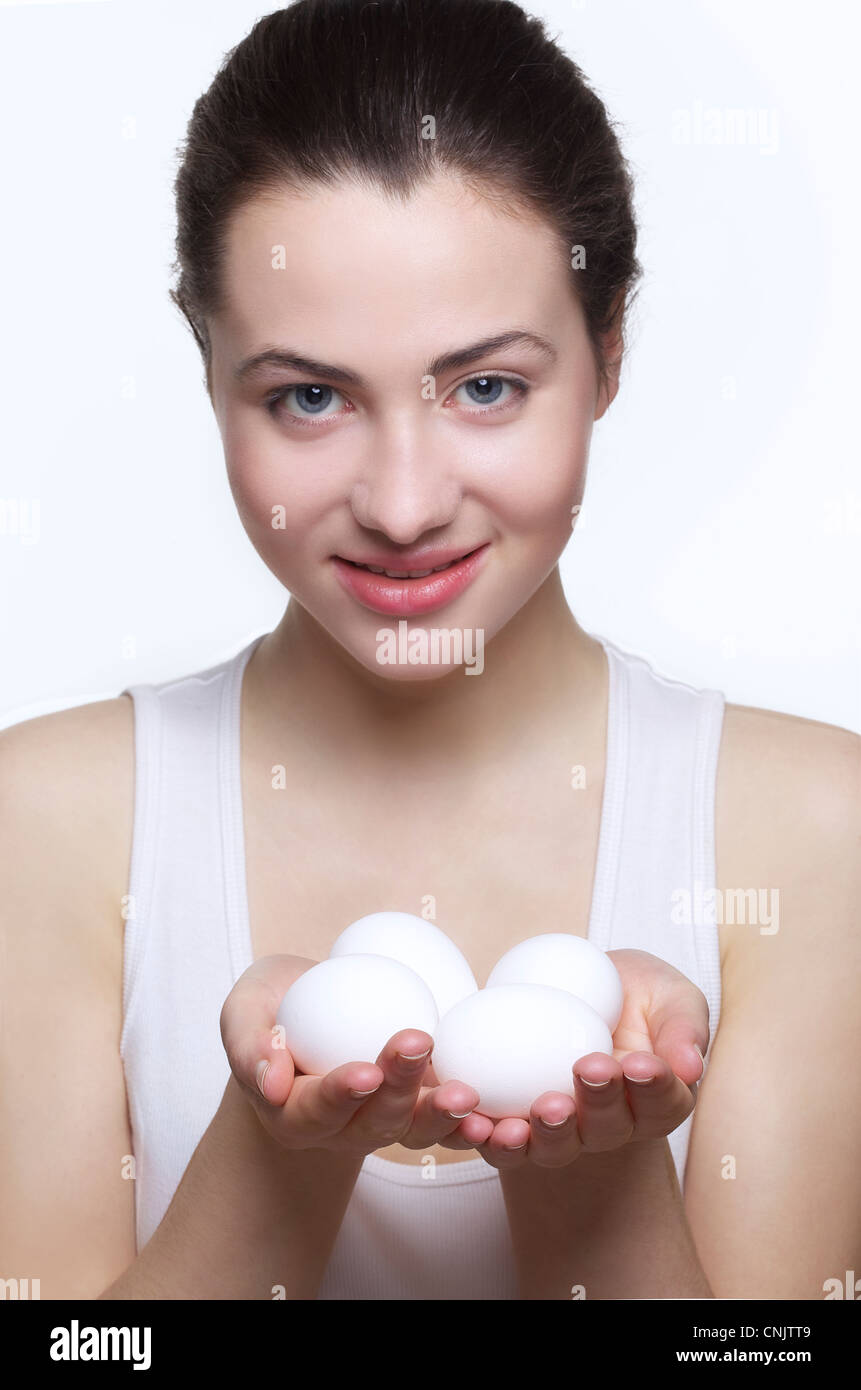 Beautiful young woman holding white eggs Stock Photo