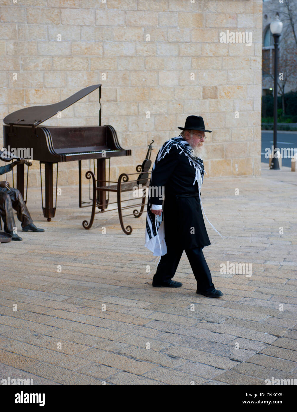 Middle East Israel Jerusalem - A Jewish religious man walking past a public art sculpture of a piano Stock Photo