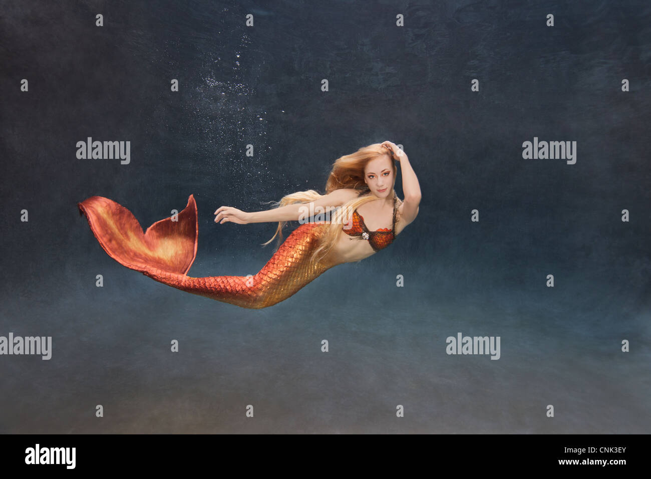 Young mermaid swimming underwater Stock Photo