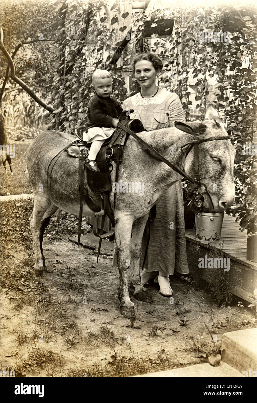 Pretty Young Mother with Young Son Riding Donkey Stock Photo