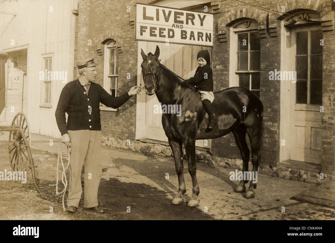 Young Boy on Horseback at Livery and Feed Barn Stock Photo