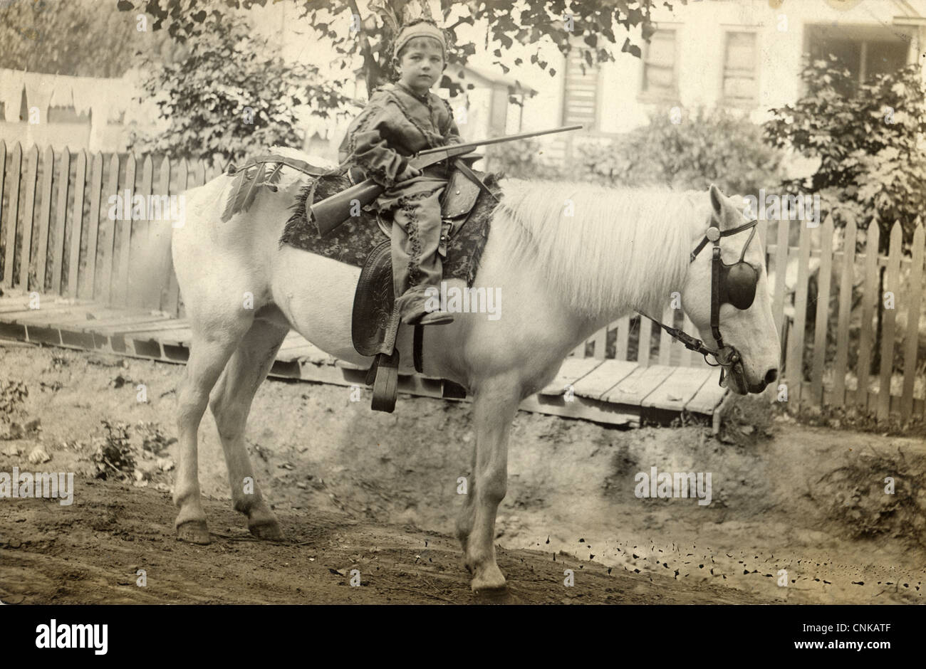 Armed Little Boy Indian Chief Riding a White Horse Stock Photo