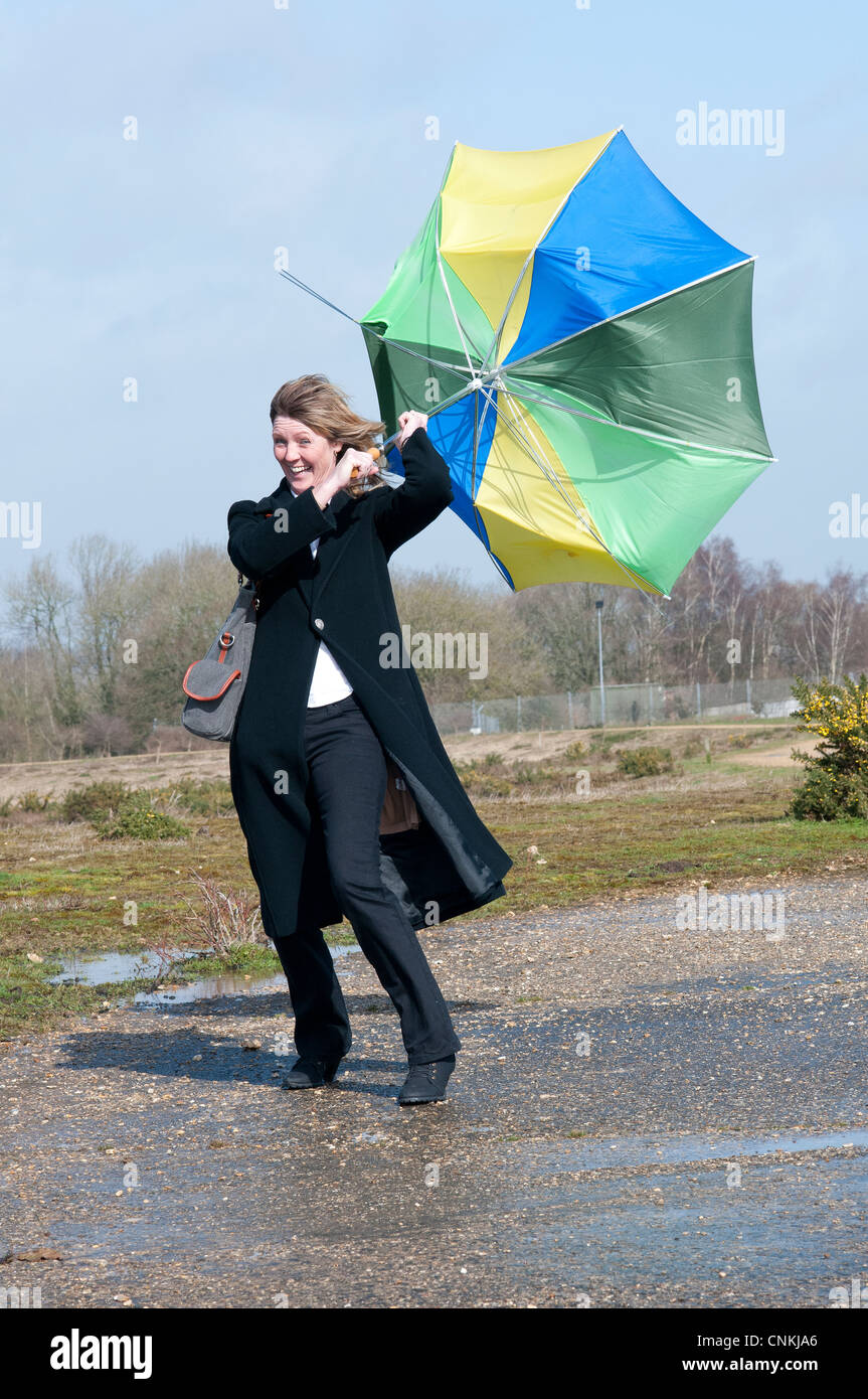 Woman struggling to hold her umbrella in high winds Stock Photo Alamy
