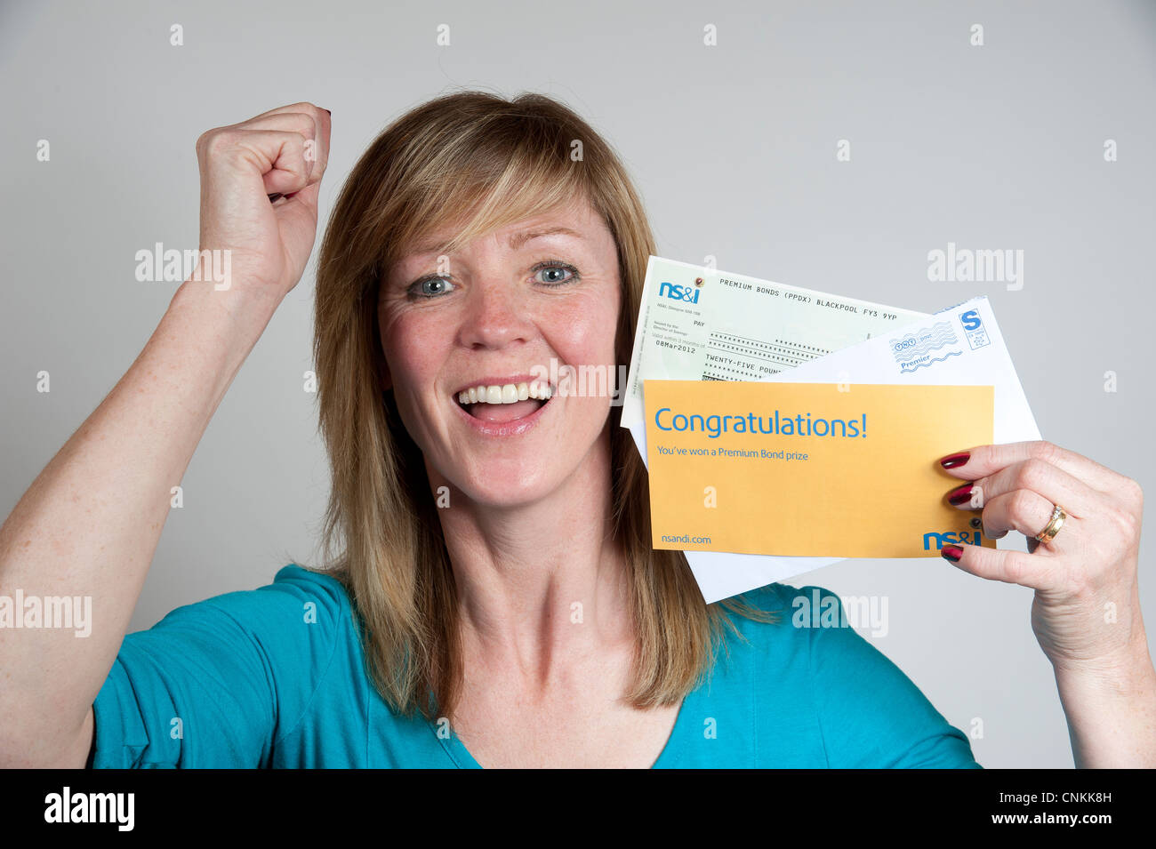 UK Premium Bond winner holding cheque from NS&I Stock Photo Alamy