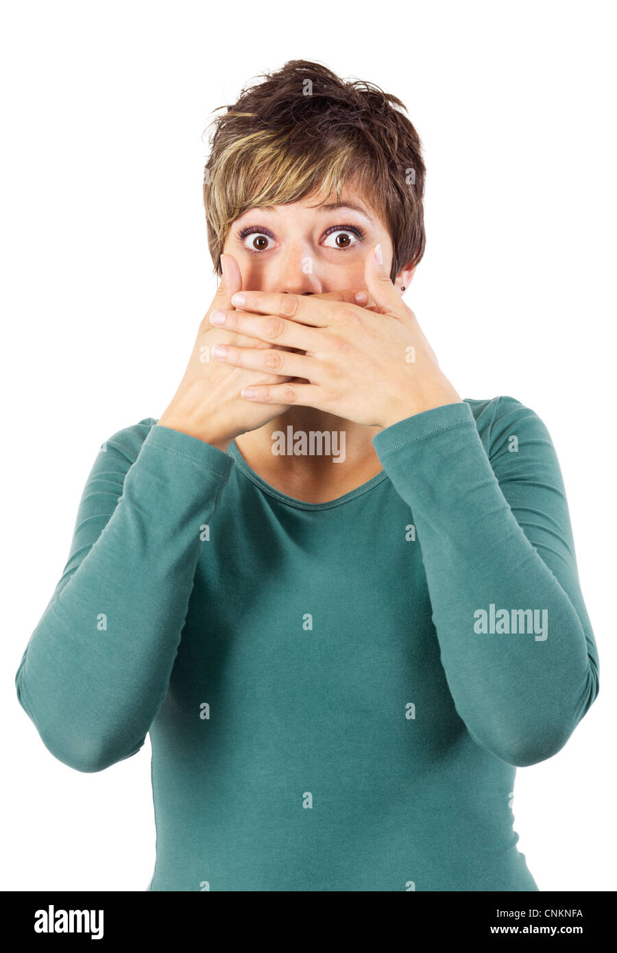 Surprise looking young woman covering her mouth, like one of the three monkeys. Isolated studio shot against a white background. Stock Photo