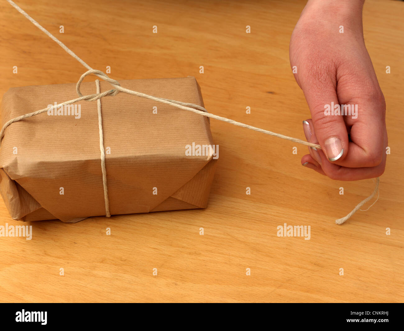 Tying Knot In String Around A Parcel Stock Photo